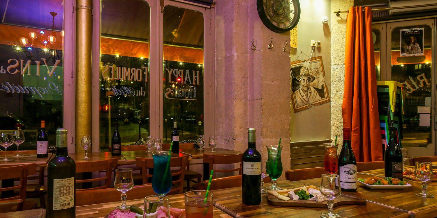 Tablées dressées avec vins et planches, lumière chaude